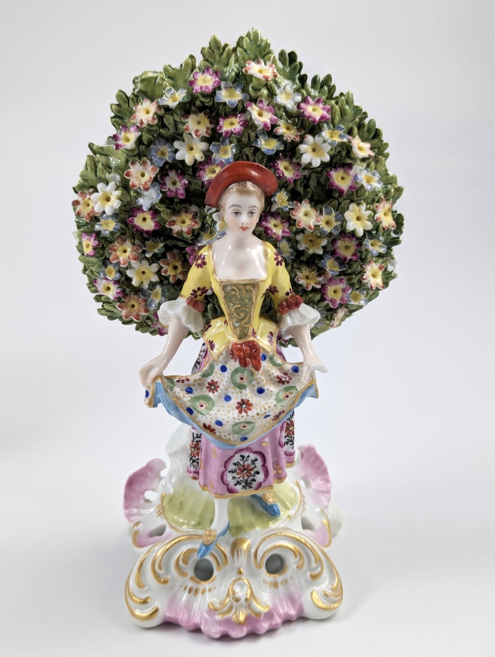 A pair of 19th-century Samson of Paris hand-painted porcelain figures standing against dense, flowering green bocage backgrounds on scrollwork bases. View VIII