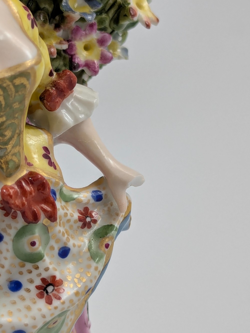 A pair of 19th-century Samson of Paris hand-painted porcelain figures standing against dense, flowering green bocage backgrounds on scrollwork bases. View X