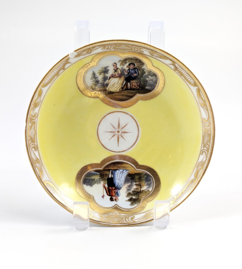 An antique nineteenth-century Meissen porcelain demitasse cup and saucer in yellow featuring hand-painted pastoral scenes set within intricate gilded cartouches. View XI