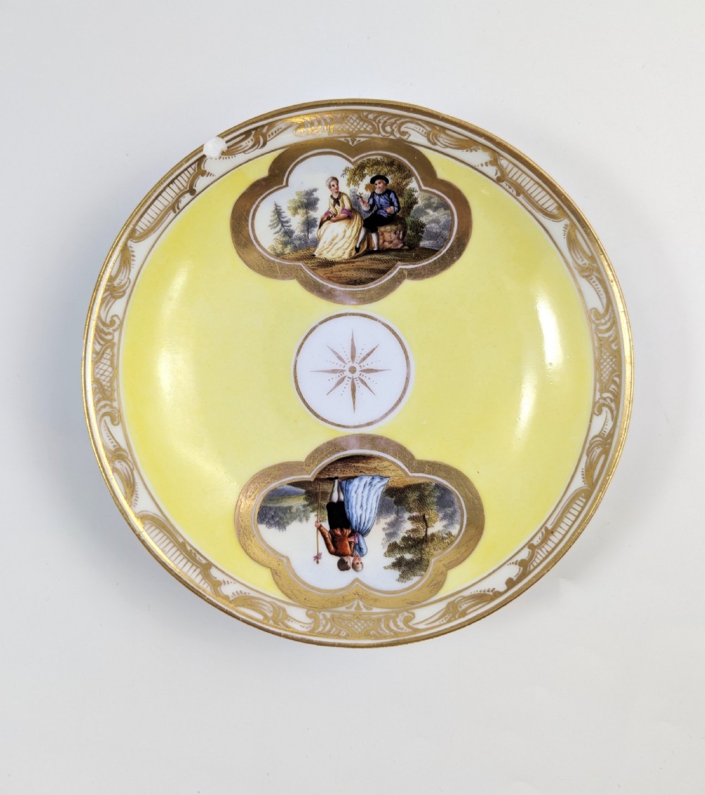 An antique nineteenth-century Meissen porcelain demitasse cup and saucer in yellow featuring hand-painted pastoral scenes set within intricate gilded cartouches. View XII