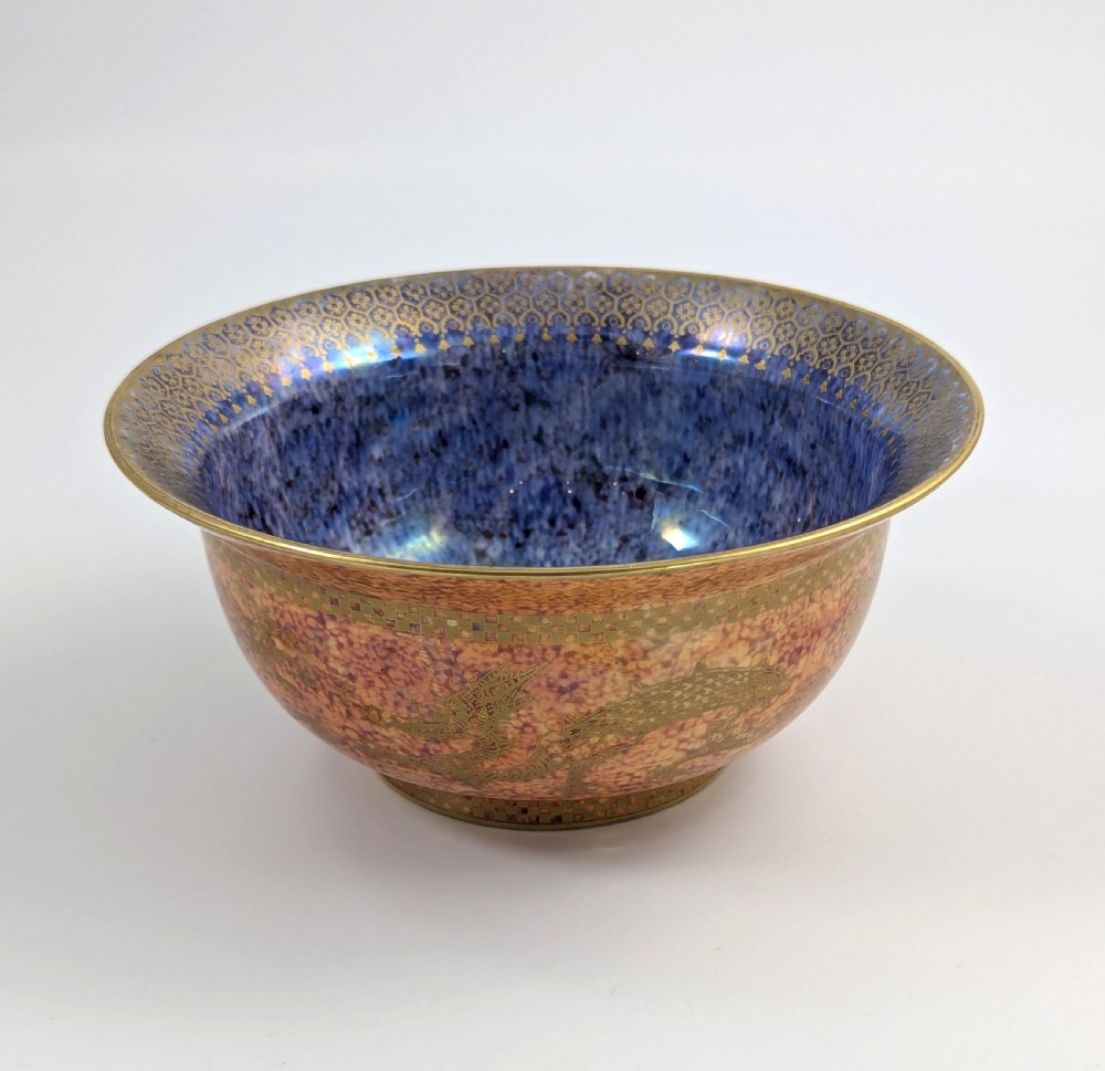 A circular ceramic bowl displaying a mottled orange and gold exterior with a deep speckled blue interior bordered by detailed gilt geometric patterns. View III