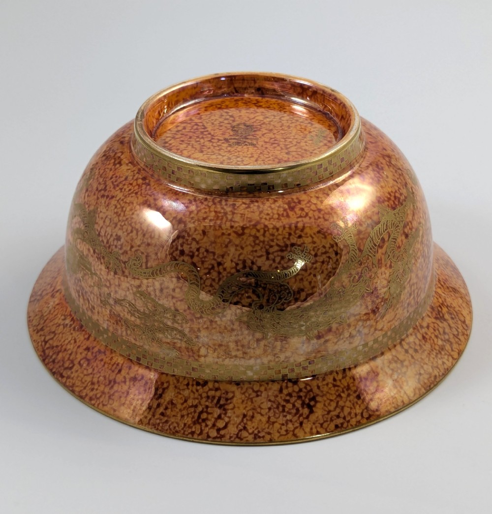 A circular ceramic bowl displaying a mottled orange and gold exterior with a deep speckled blue interior bordered by detailed gilt geometric patterns. View IX