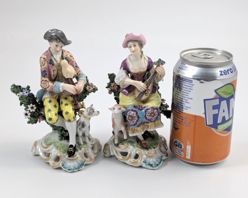 Pair of nineteenth-century Dresden porcelain figurines depicting a male bagpipe player with a dog and a female lute player with a lamb, both styled in Rococo attire on ornate bases. View VI