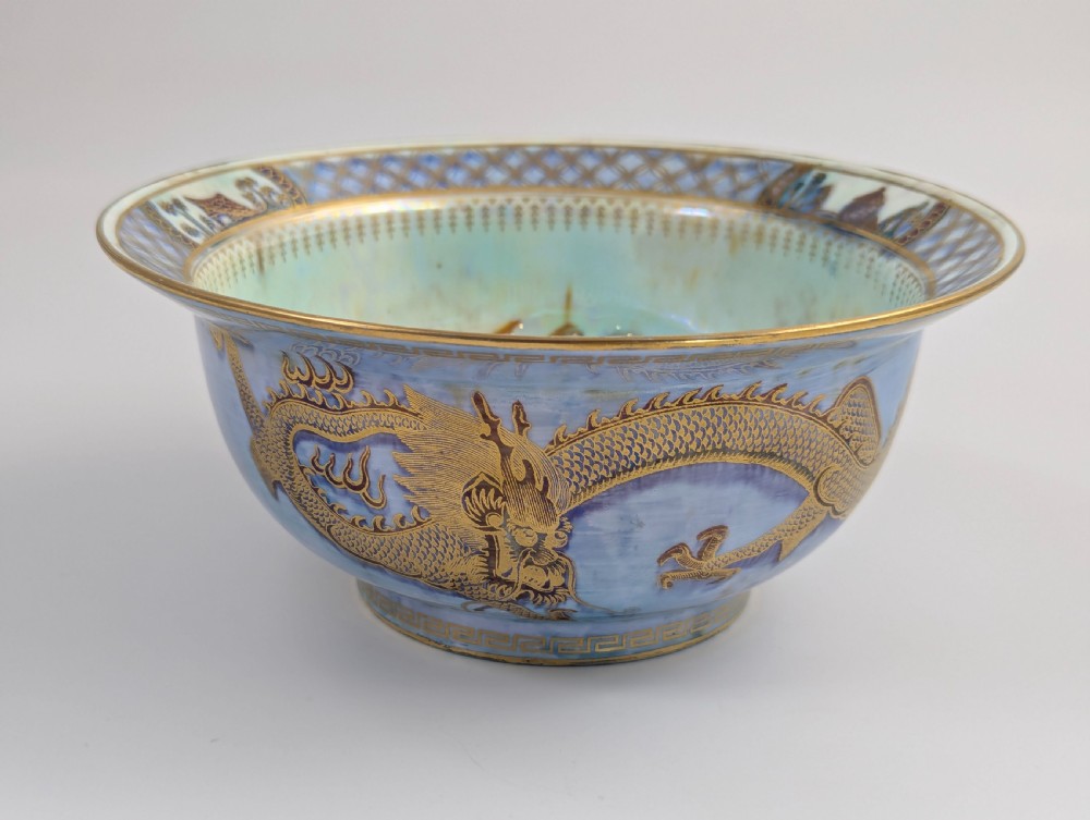 An antique light blue lustre porcelain bowl decorated with a detailed gilded dragon motif around the exterior.
