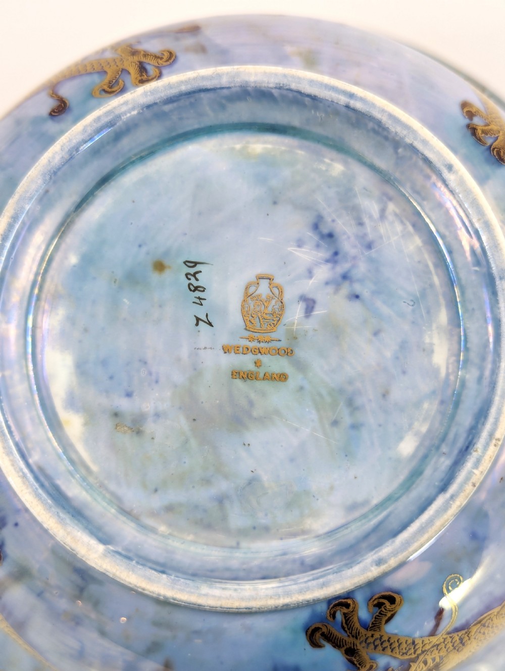 An antique light blue lustre porcelain bowl decorated with a detailed gilded dragon motif around the exterior. View IX