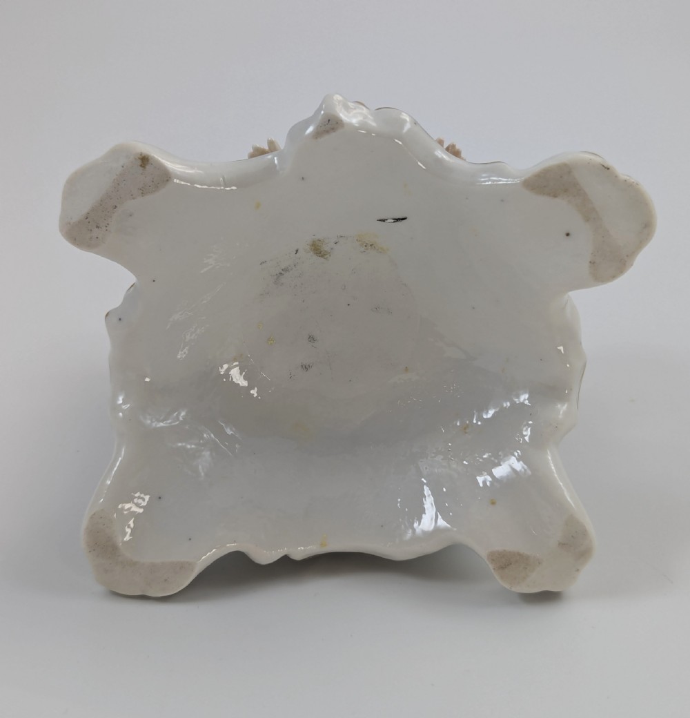An 18th-century Chelsea soft-paste porcelain figurine depicting Diana the Huntress seated on a Rococo scroll base with a hound and quiver. View IX