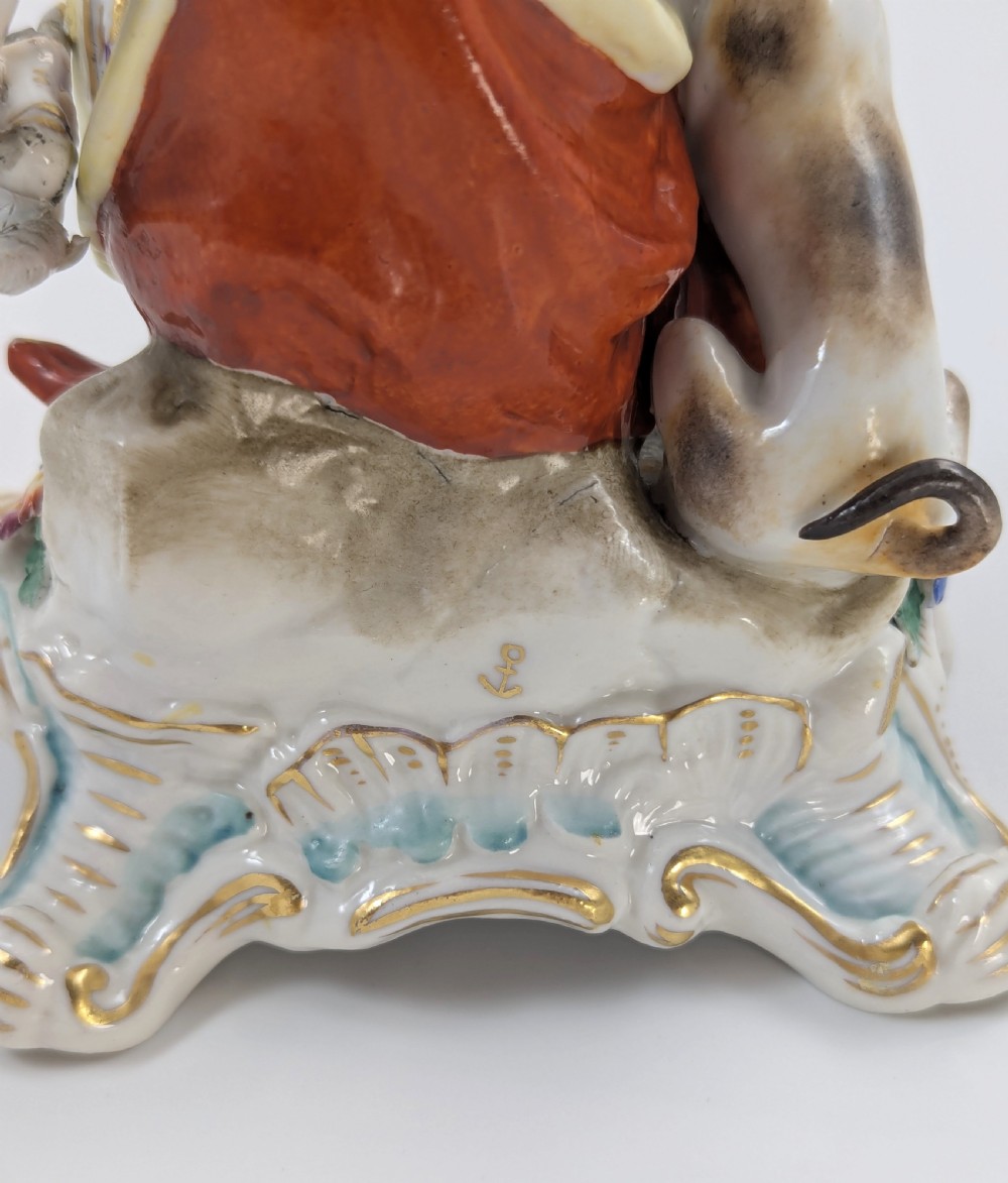 An 18th-century Chelsea soft-paste porcelain figurine depicting Diana the Huntress seated on a Rococo scroll base with a hound and quiver. View X
