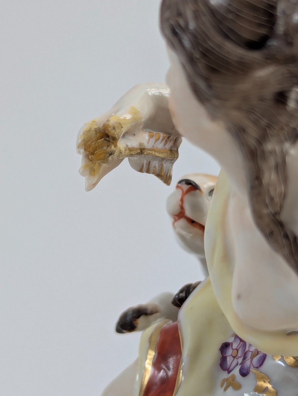 An 18th-century Chelsea soft-paste porcelain figurine depicting Diana the Huntress seated on a Rococo scroll base with a hound and quiver. View XII