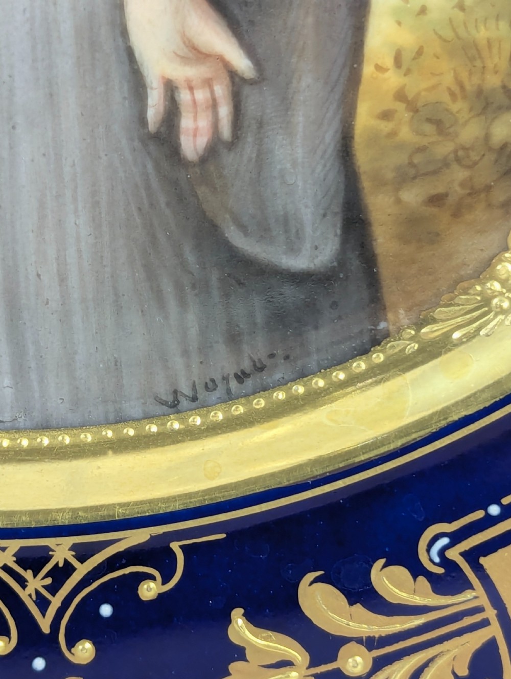 A circular porcelain cabinet plate with a central hand-painted portrait of a woman in draped attire set within a cobalt blue rim embellished with gold gilding. View IV
