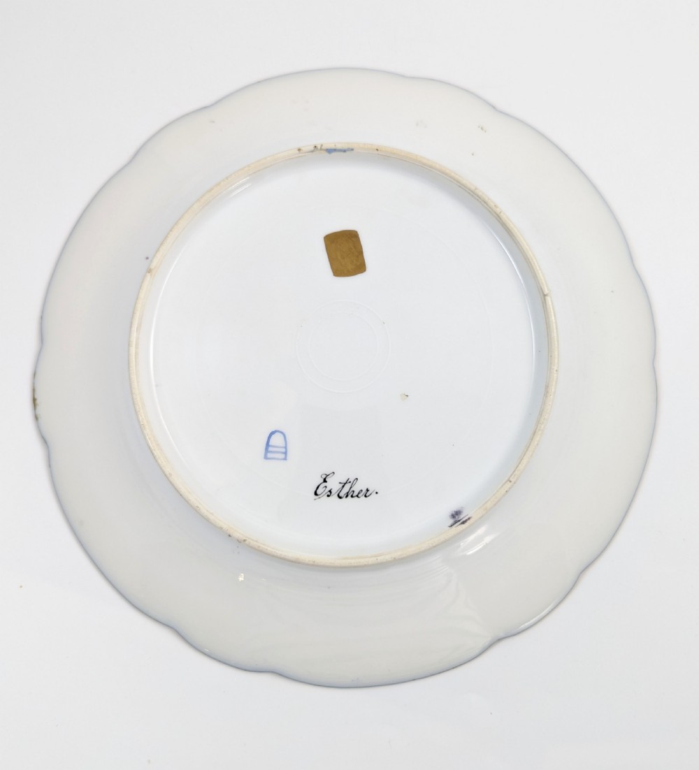 A circular porcelain cabinet plate with a central hand-painted portrait of a woman in draped attire set within a cobalt blue rim embellished with gold gilding. View VII