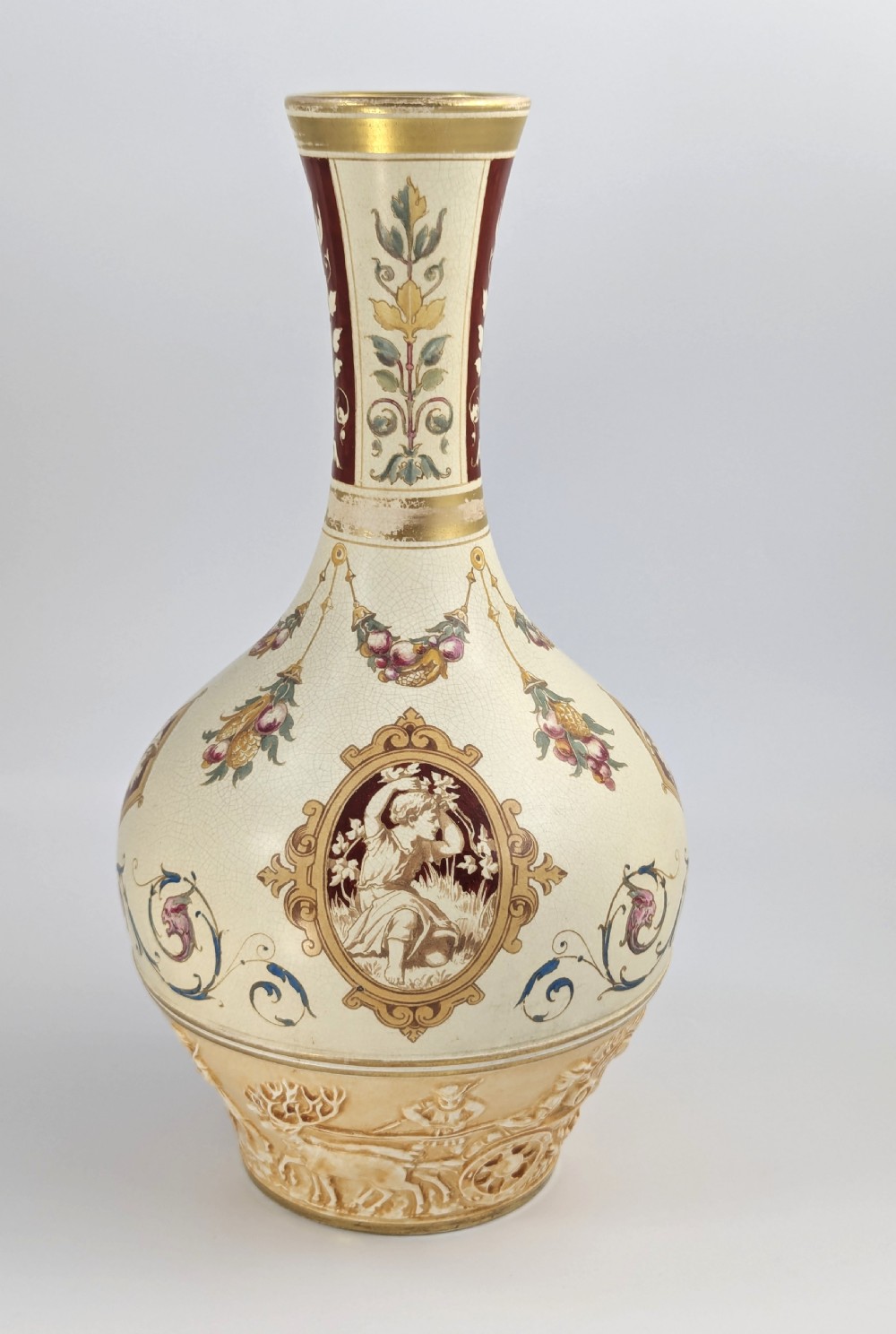 A late 19th-century Wedgwood ceramic vase featuring a slender neck, bulbous body decorated with classical cartouches and gilt details, resting on a carved relief base. View III