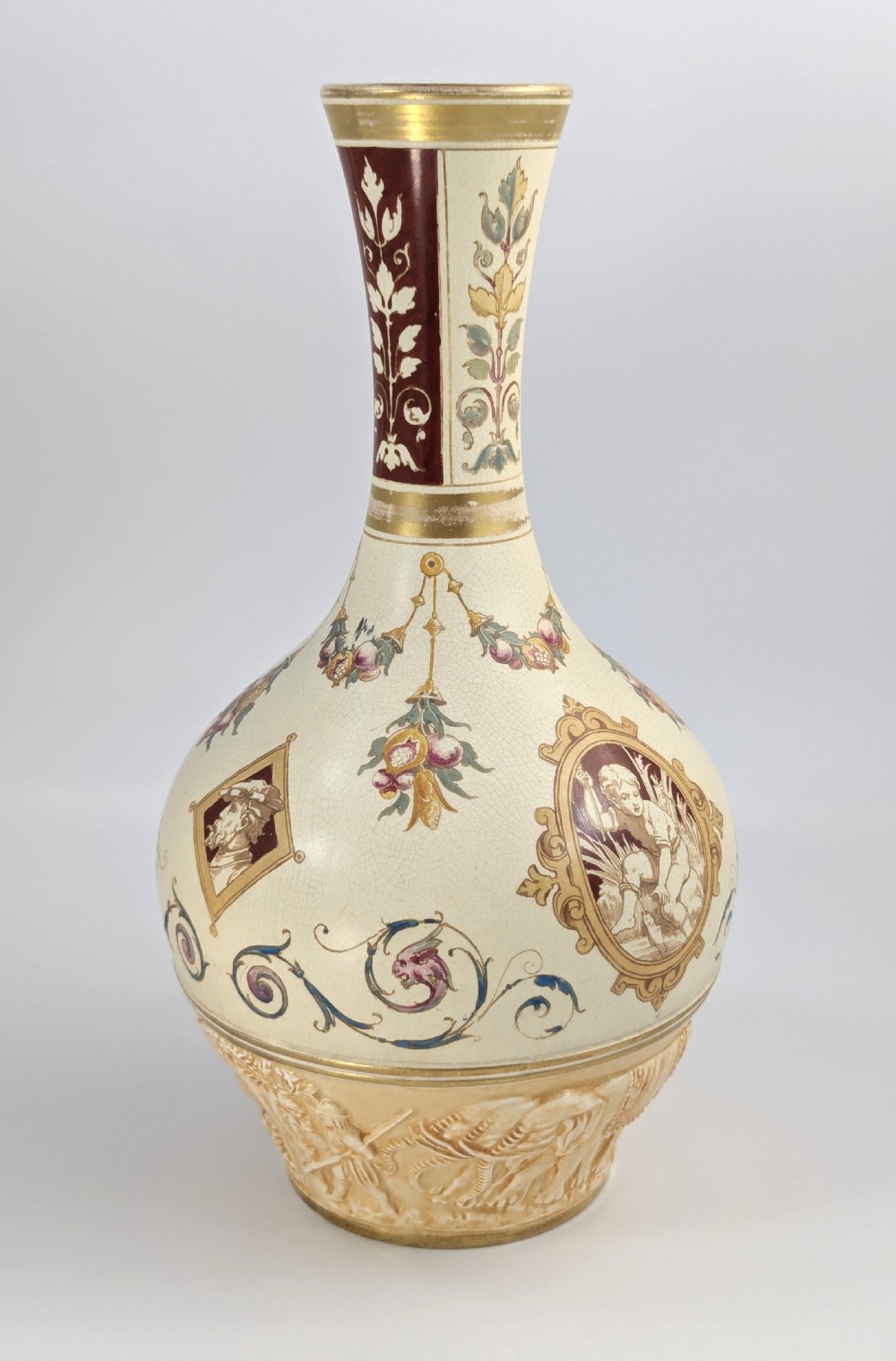 A late 19th-century Wedgwood ceramic vase featuring a slender neck, bulbous body decorated with classical cartouches and gilt details, resting on a carved relief base. View VIII