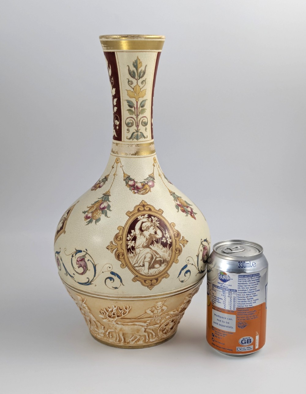 A late 19th-century Wedgwood ceramic vase featuring a slender neck, bulbous body decorated with classical cartouches and gilt details, resting on a carved relief base. View XVI