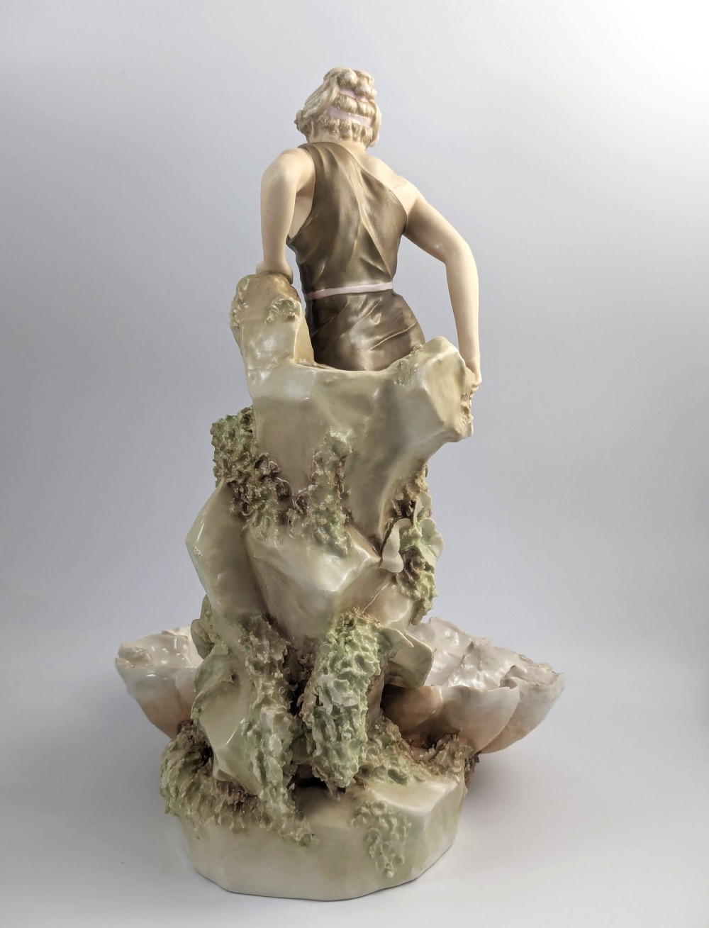 An Art Nouveau Royal Dux porcelain centrepiece depicting a draped female bather standing atop rockwork above a large shell-shaped basin. View IV