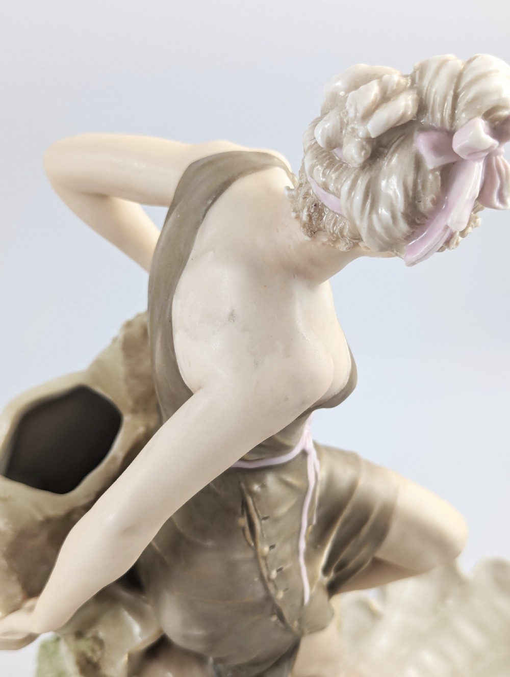 An Art Nouveau Royal Dux porcelain centrepiece depicting a draped female bather standing atop rockwork above a large shell-shaped basin. View X