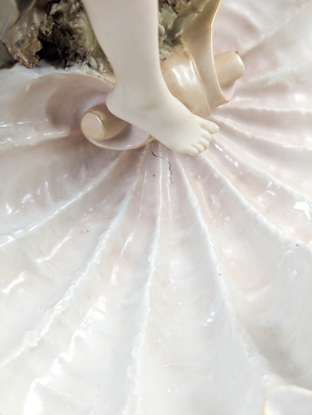 An Art Nouveau Royal Dux porcelain centrepiece depicting a draped female bather standing atop rockwork above a large shell-shaped basin. View XI