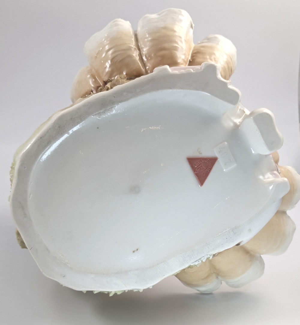 An Art Nouveau Royal Dux porcelain centrepiece depicting a draped female bather standing atop rockwork above a large shell-shaped basin. View XII