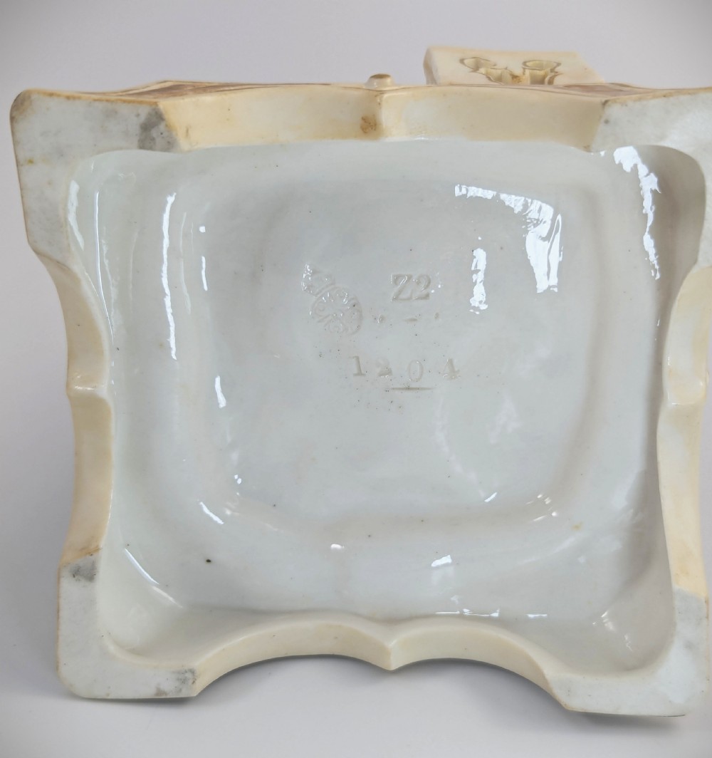 A late nineteenth-century Royal Worcester blush ivory porcelain figurine depicting a seated Indian craftsman working on an ornate pedestal base. View IX
