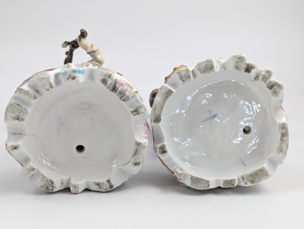 A pair of 18th-century German porcelain figurines depicting a male and female gardener standing beside fruiting trees on Rococo scrollwork bases. View VII