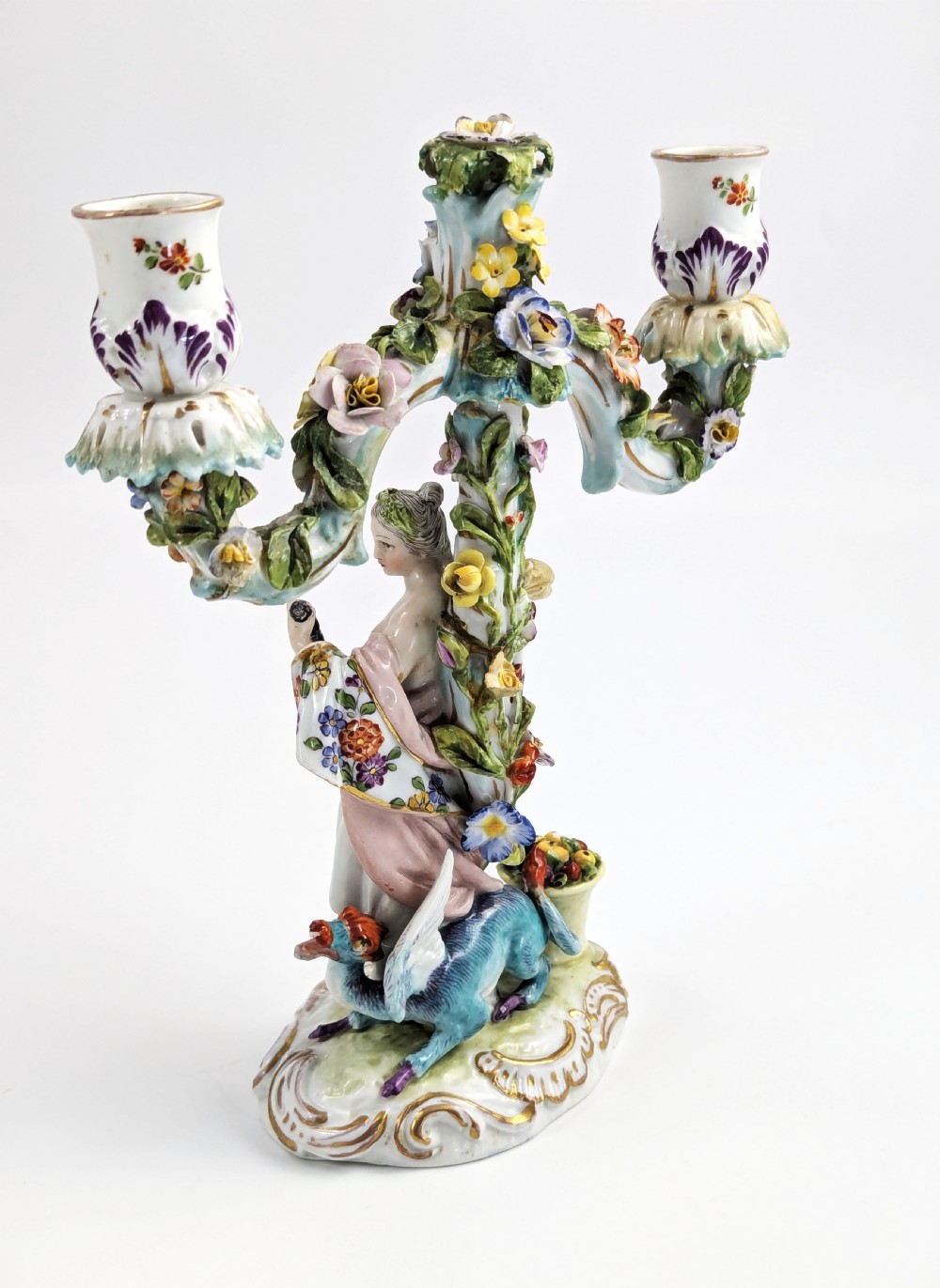 A nineteenth-century Dresden porcelain three-light candelabra featuring a central allegorical figure draped in floral fabric standing on a gilded Rococo base surrounded by encrusted porcelain flowers. View III