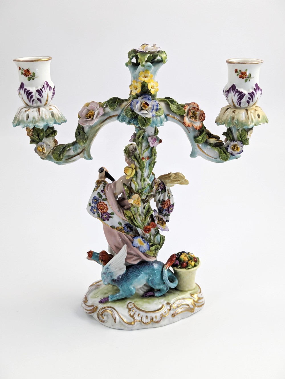 A nineteenth-century Dresden porcelain three-light candelabra featuring a central allegorical figure draped in floral fabric standing on a gilded Rococo base surrounded by encrusted porcelain flowers. View IV