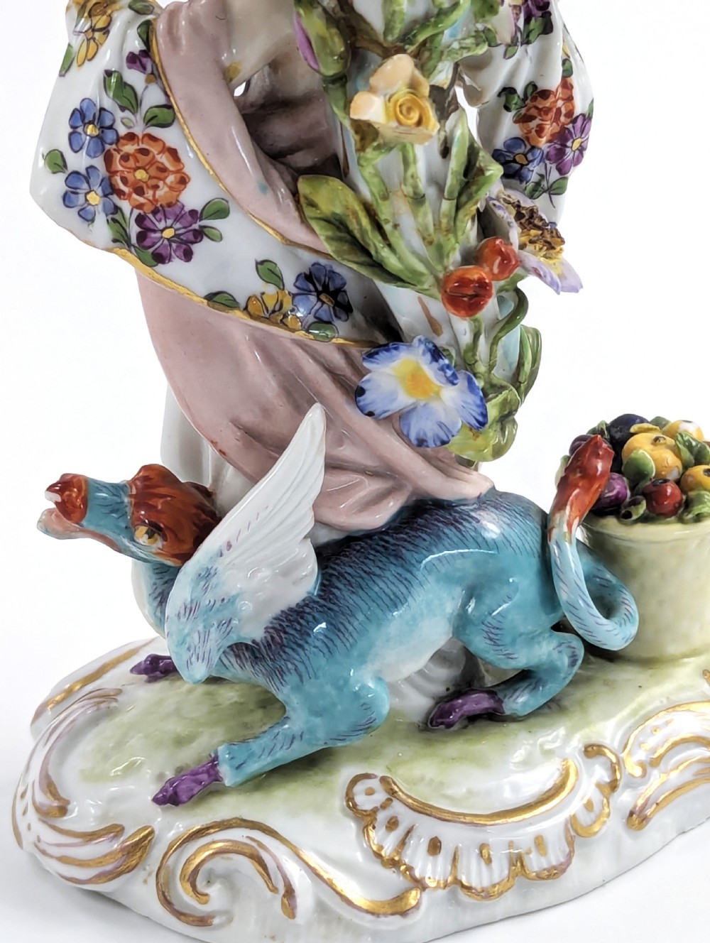 A nineteenth-century Dresden porcelain three-light candelabra featuring a central allegorical figure draped in floral fabric standing on a gilded Rococo base surrounded by encrusted porcelain flowers. View X