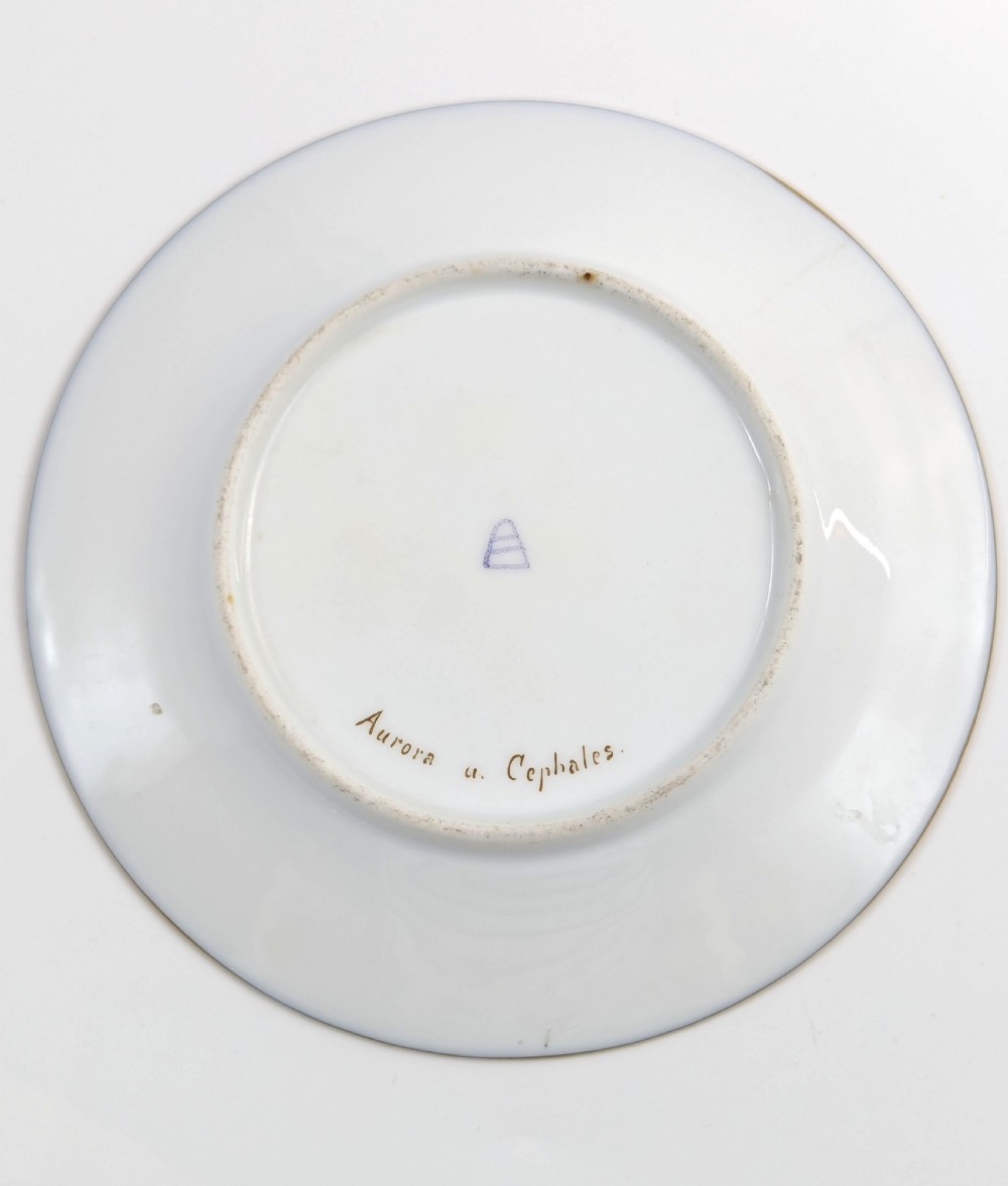 A circular porcelain cabinet plate featuring a central hand-painted scene of Aurora and Cephalus framed by a wide cobalt blue border with intricate gold scrollwork gilding. View V