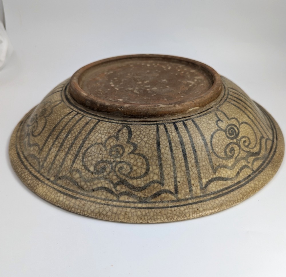 A circular antique ceramic dish featuring a central underglaze grey fish design on a crazed cream ground. View VII