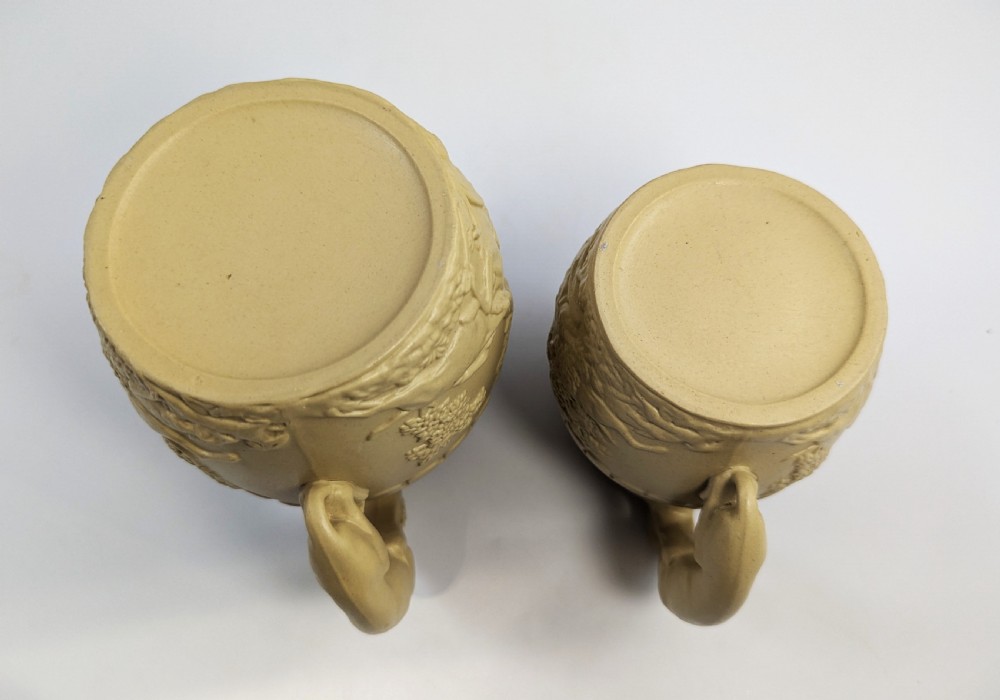 A graduated set of three buff yellow Regency ceramic pitchers featuring relief-moulded stag hunting scenes and sculpted hound handles. View VIII