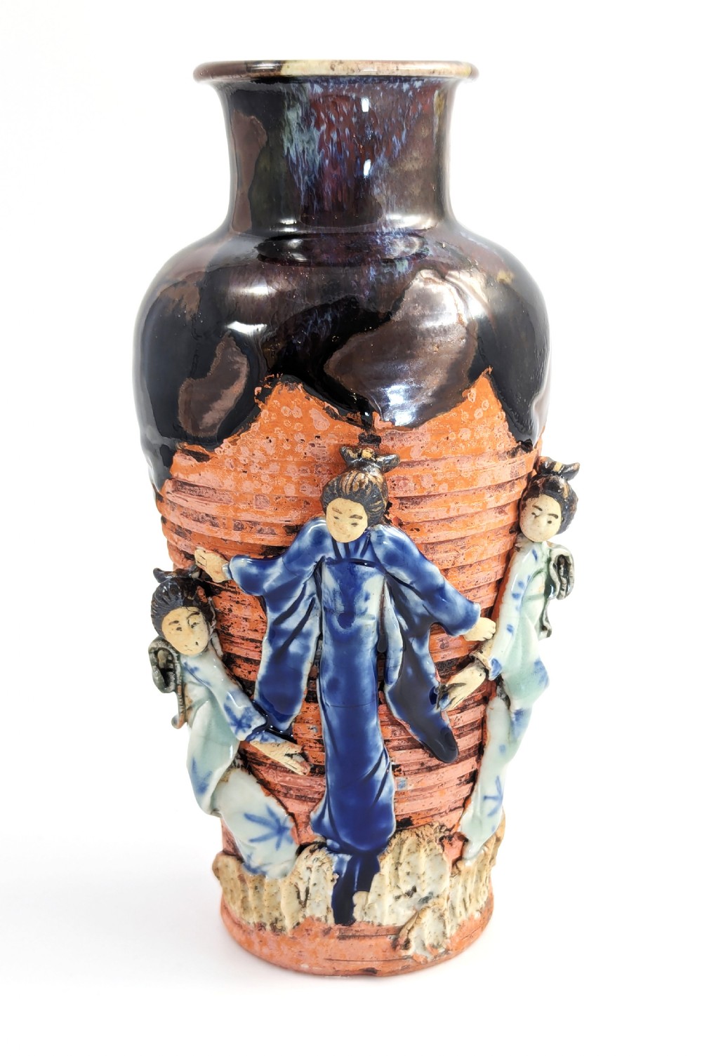 A Japanese Sumida Gawa pottery vase featuring an oxblood flambe glazed neck and applied relief figures on a ribbed terracotta body. View III