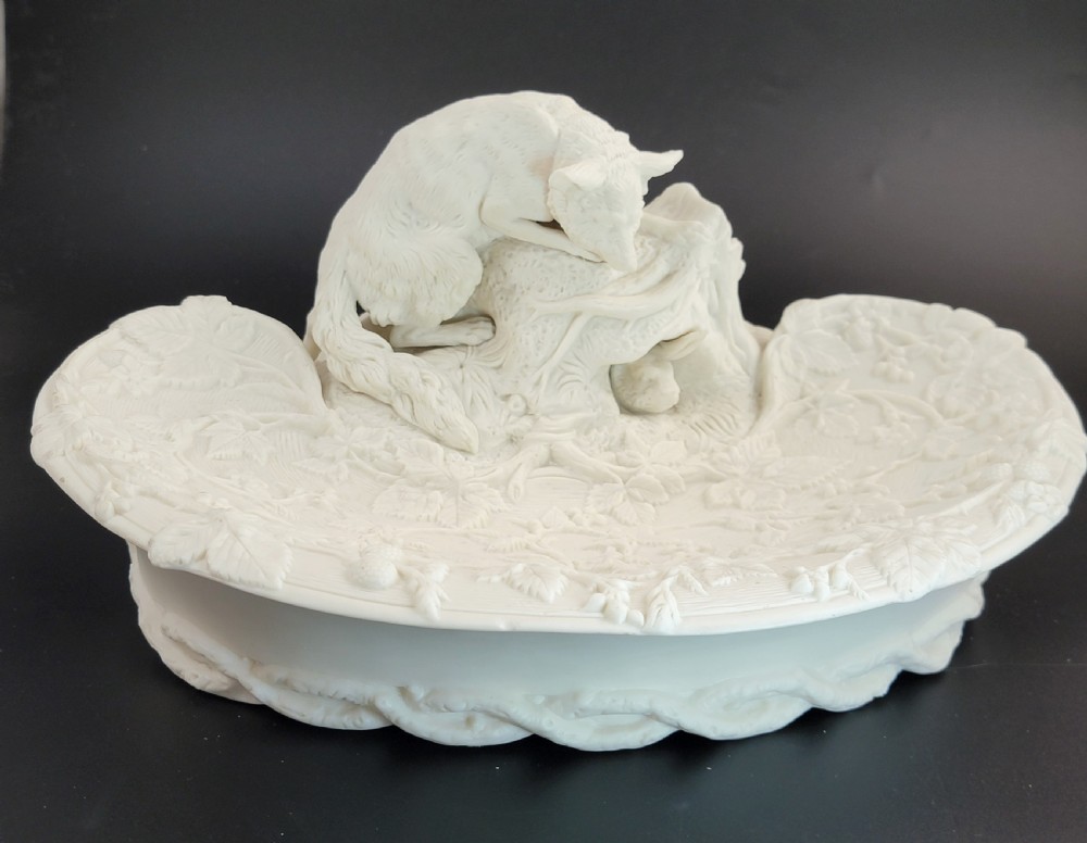 An off-white Parian porcelain centrepiece dish featuring a sculpted fox perched on a central stump above a rabbit in a hollow base surrounded by leaves. View VII
