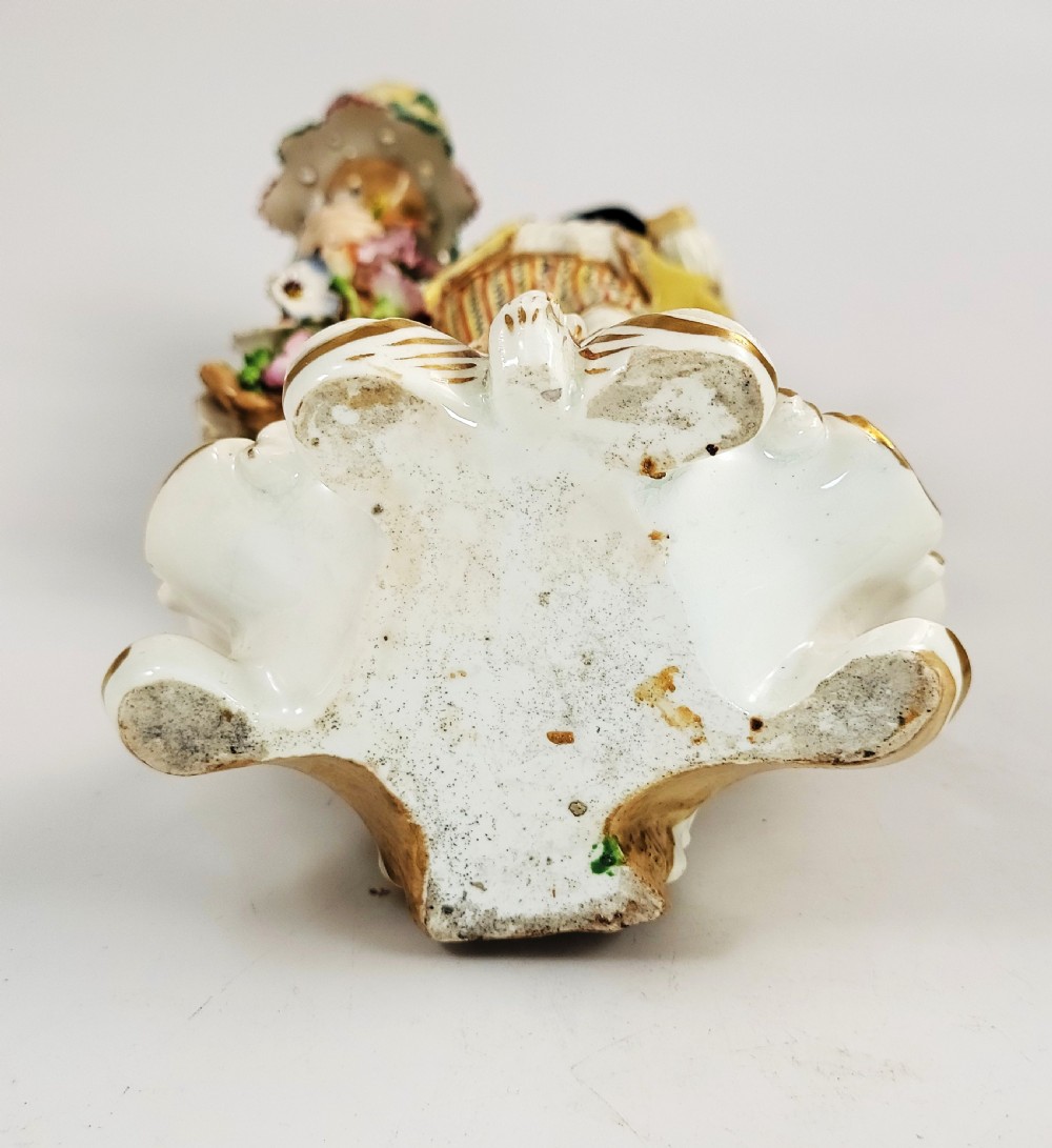 A pair of 18th-century Georgian Derby soft-paste porcelain figural candlesticks depicting a male and female figure in period dress beside candle sconces adorned with colourful flowers and gilt Rococo scrollwork. View VII