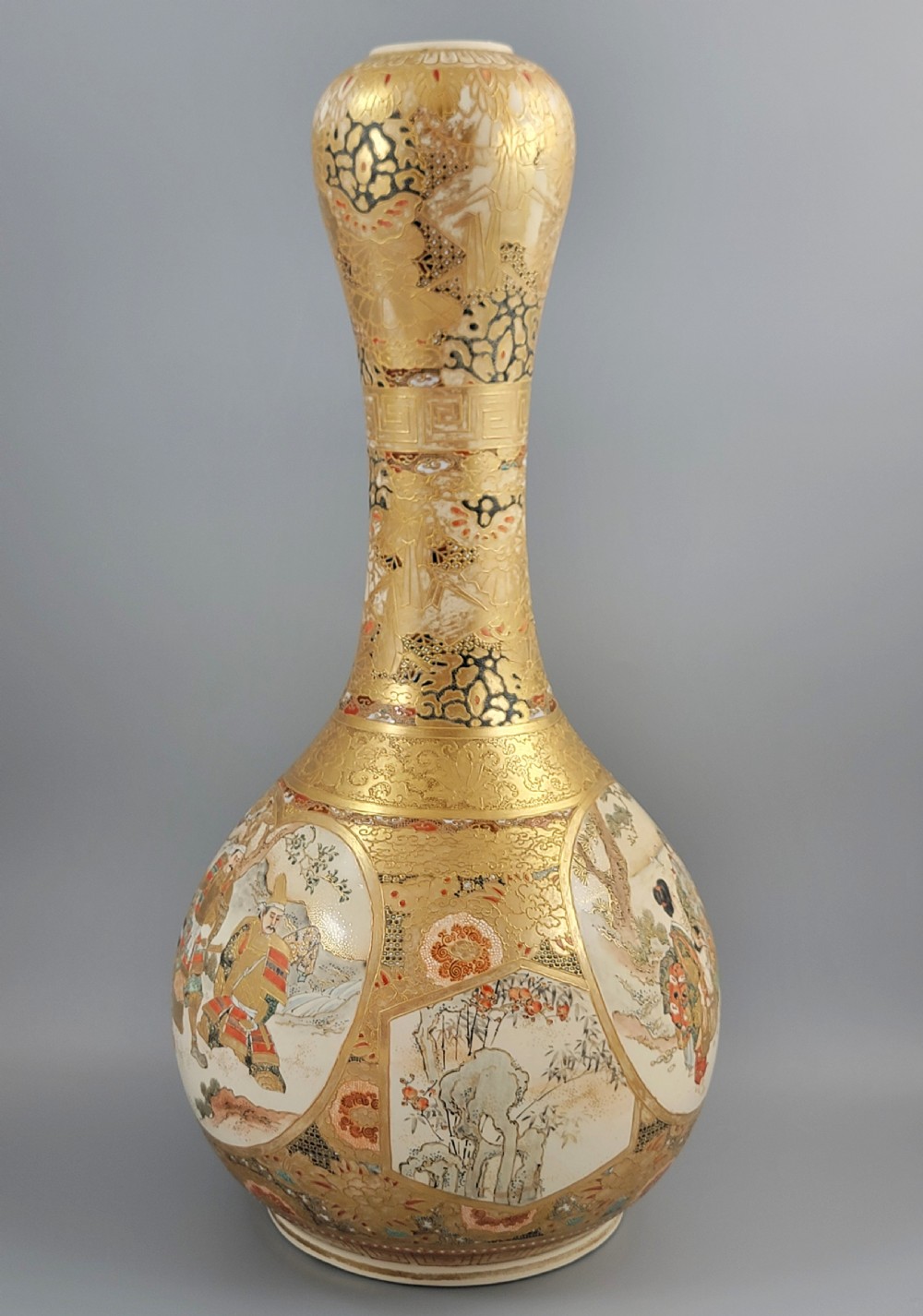 A Japanese Satsuma earthenware vase featuring a bulbous garlic-shaped mouth, intricate gilded borders, and painted panels depicting samurai warriors. View II
