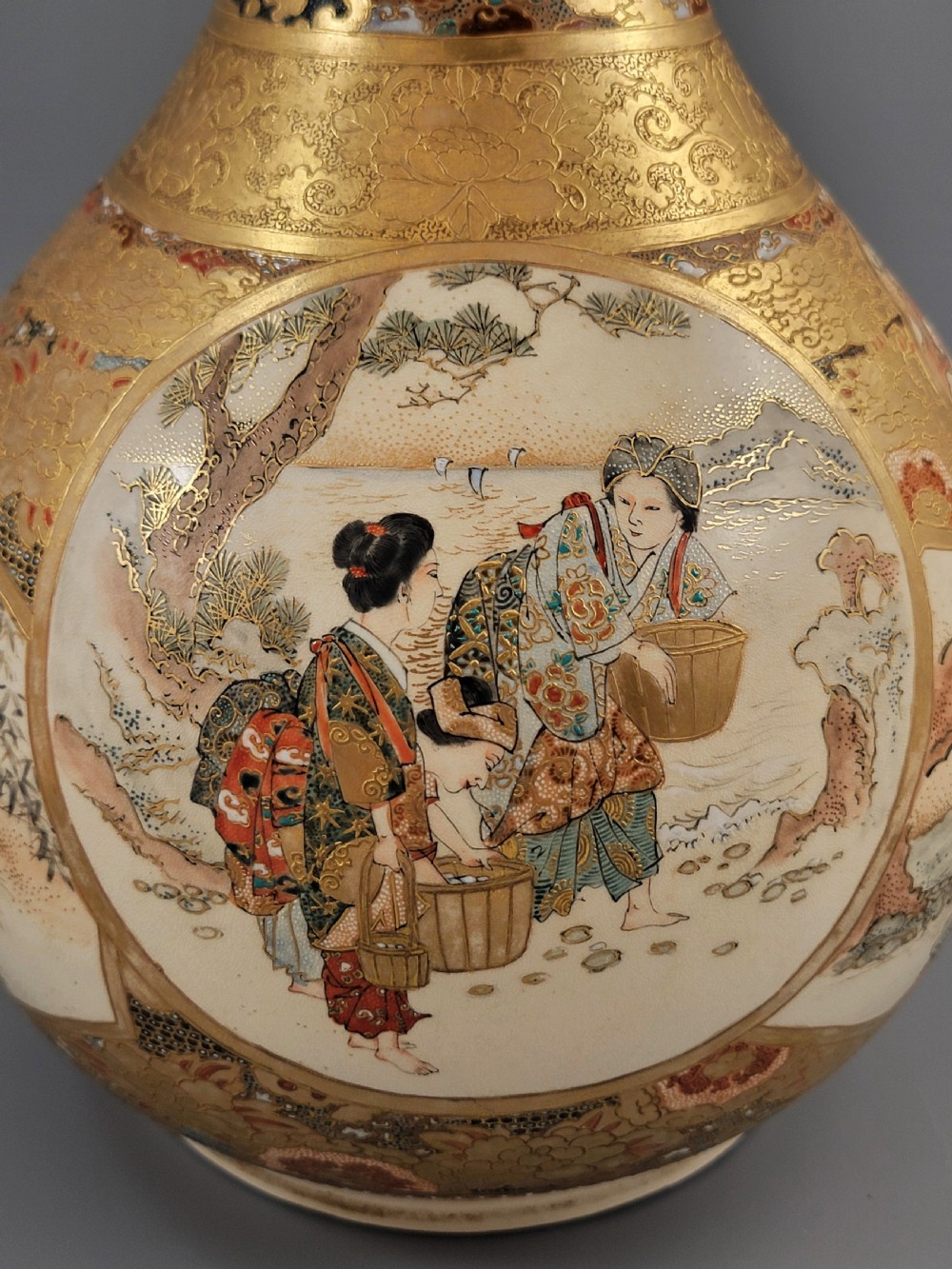 A Japanese Satsuma earthenware vase featuring a bulbous garlic-shaped mouth, intricate gilded borders, and painted panels depicting samurai warriors. View IX