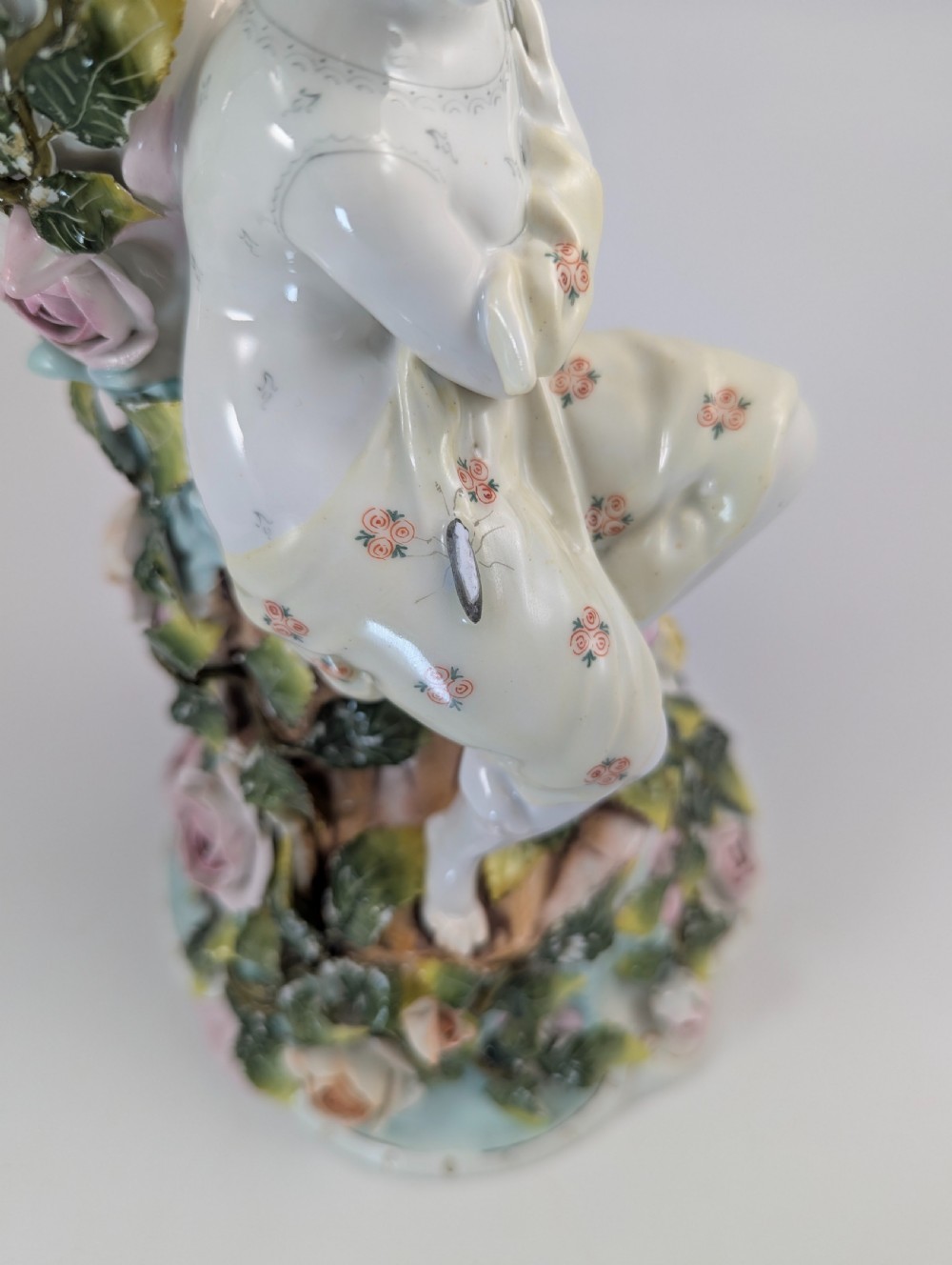 A Sitzendorf porcelain four-light candelabra featuring a seated female figure, encrusted roses, foliage, and three scrolling branch arms. View XI