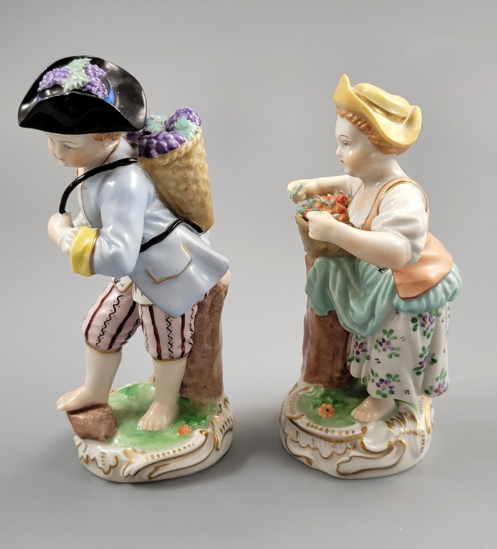 Pair of antique hand-painted Dresden porcelain figurines depicting a boy and girl gathering fruit on gilded Rococo scroll bases. View II
