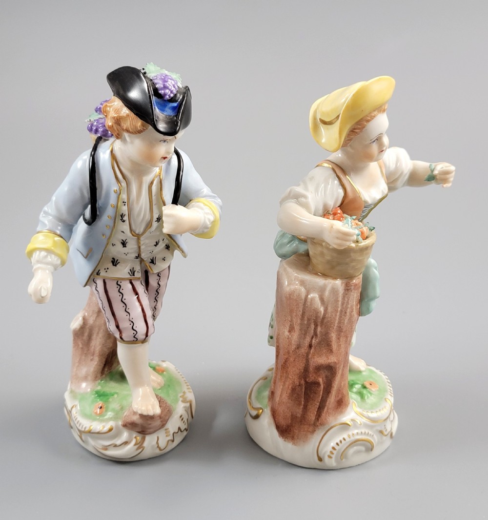 Pair of antique hand-painted Dresden porcelain figurines depicting a boy and girl gathering fruit on gilded Rococo scroll bases. View V