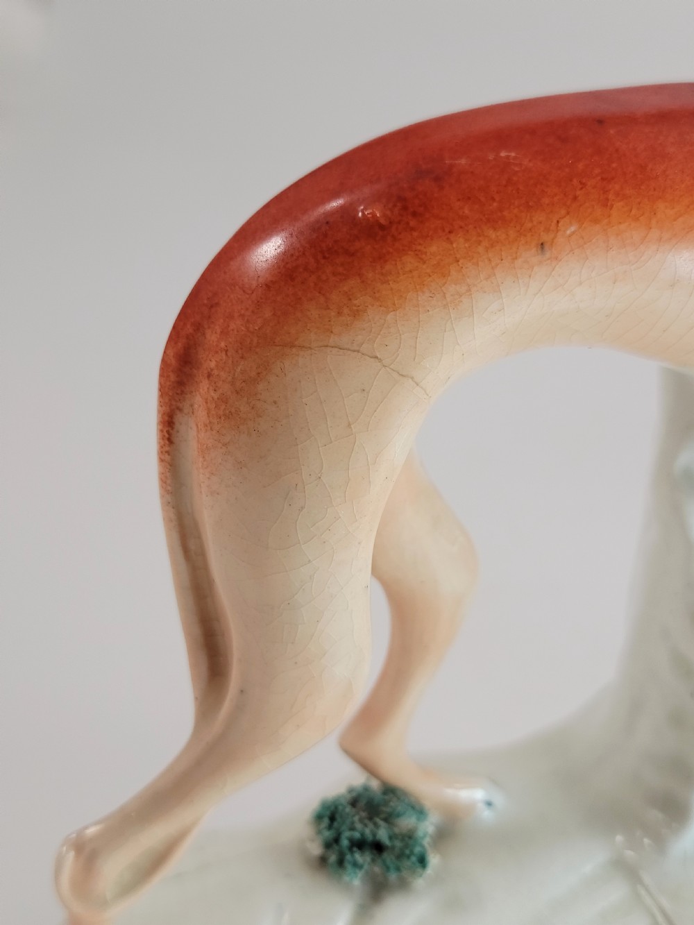 A pair of Victorian Staffordshire earthenware greyhound figurines standing on white bases with caught hares held in their mouths. View XIII