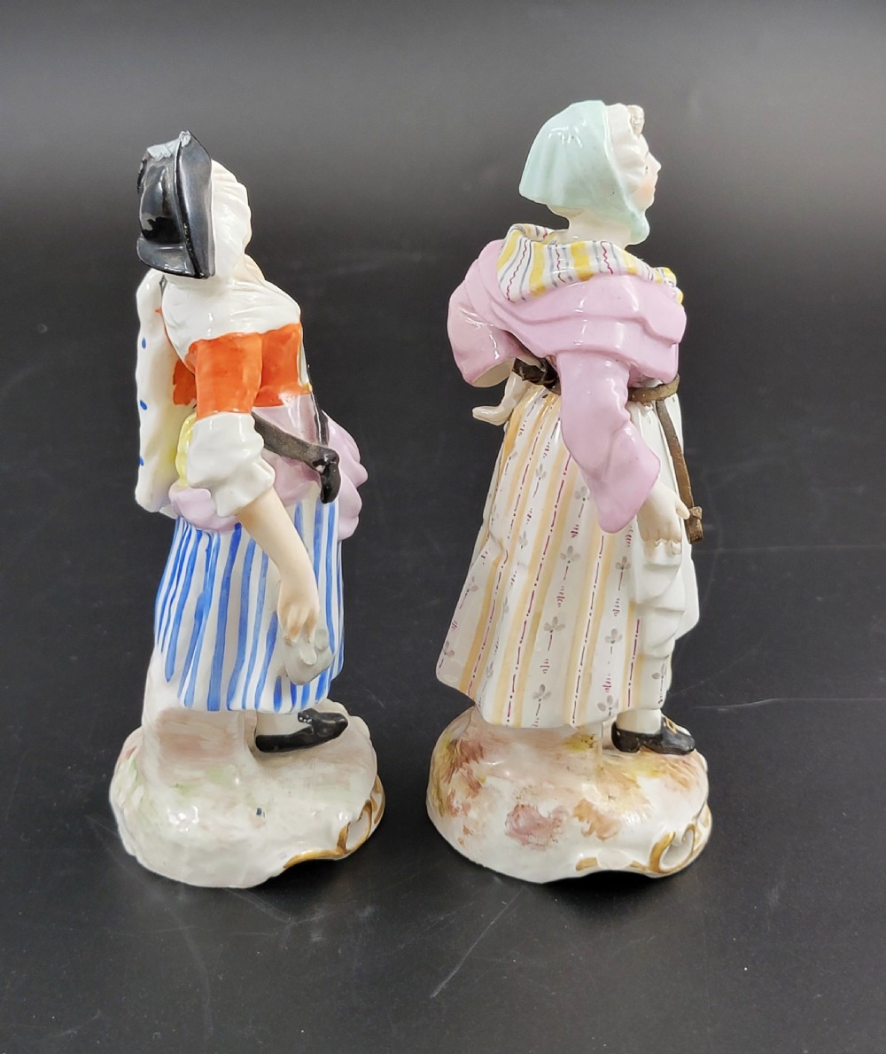 A pair of 19th-century Samson porcelain figures depicting street vendors in hand-painted colourful period dress standing on pierced scroll bases. View IV
