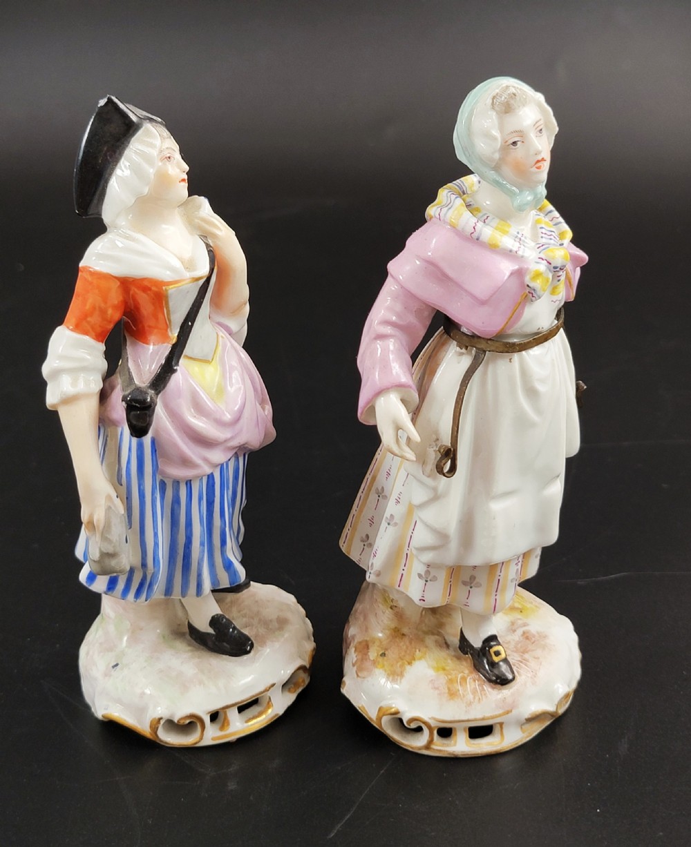 A pair of 19th-century Samson porcelain figures depicting street vendors in hand-painted colourful period dress standing on pierced scroll bases. View V