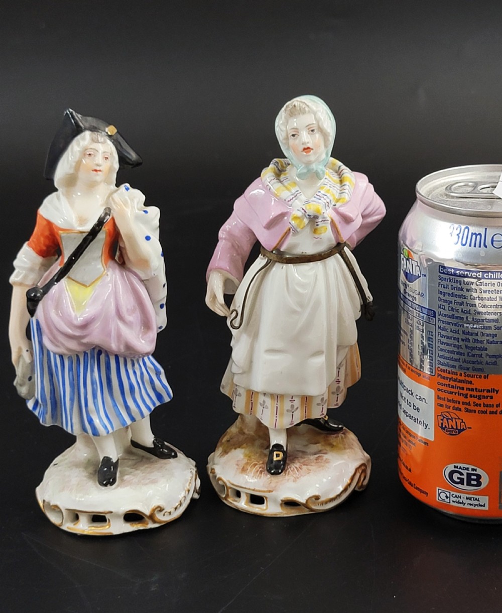 A pair of 19th-century Samson porcelain figures depicting street vendors in hand-painted colourful period dress standing on pierced scroll bases. View IX