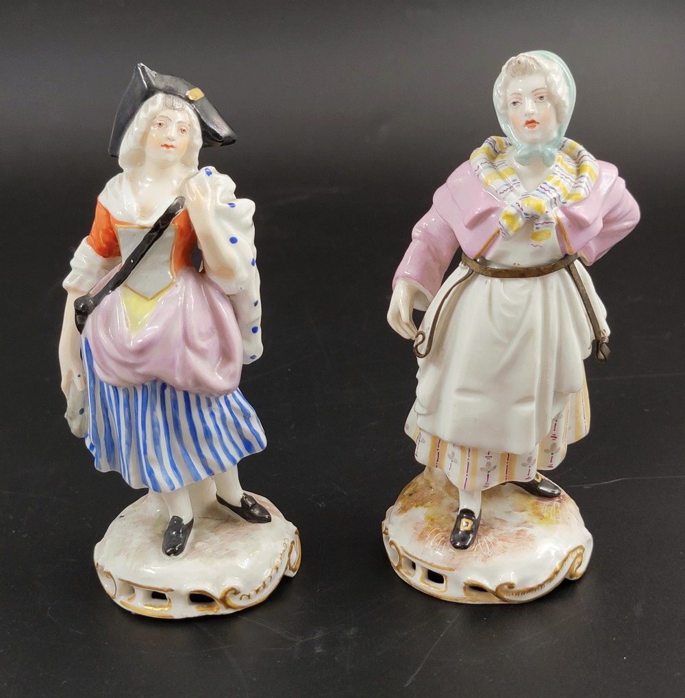 A pair of 19th-century Samson porcelain figures depicting street vendors in hand-painted colourful period dress standing on pierced scroll bases.