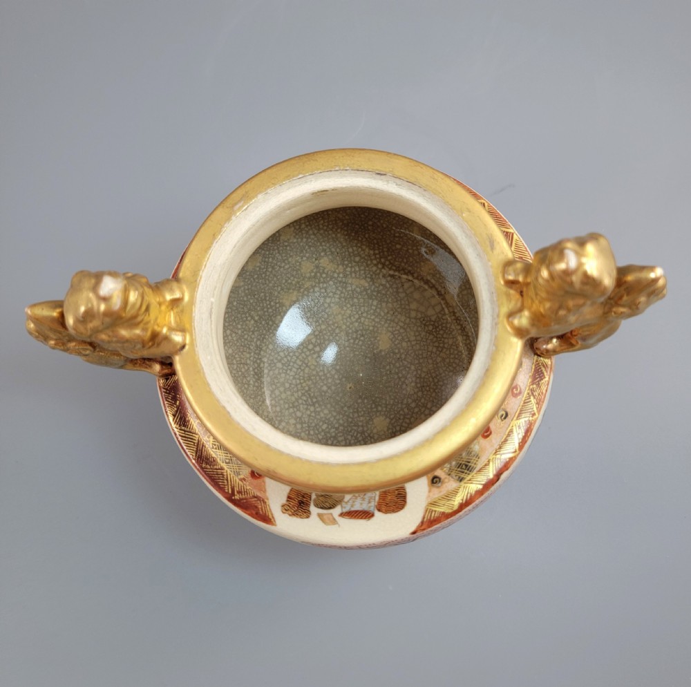 A Japanese Meiji period Satsuma earthenware incense burner featuring gilt shishi handles and finial with detailed hand-painted figures over a crackle glaze. View VII