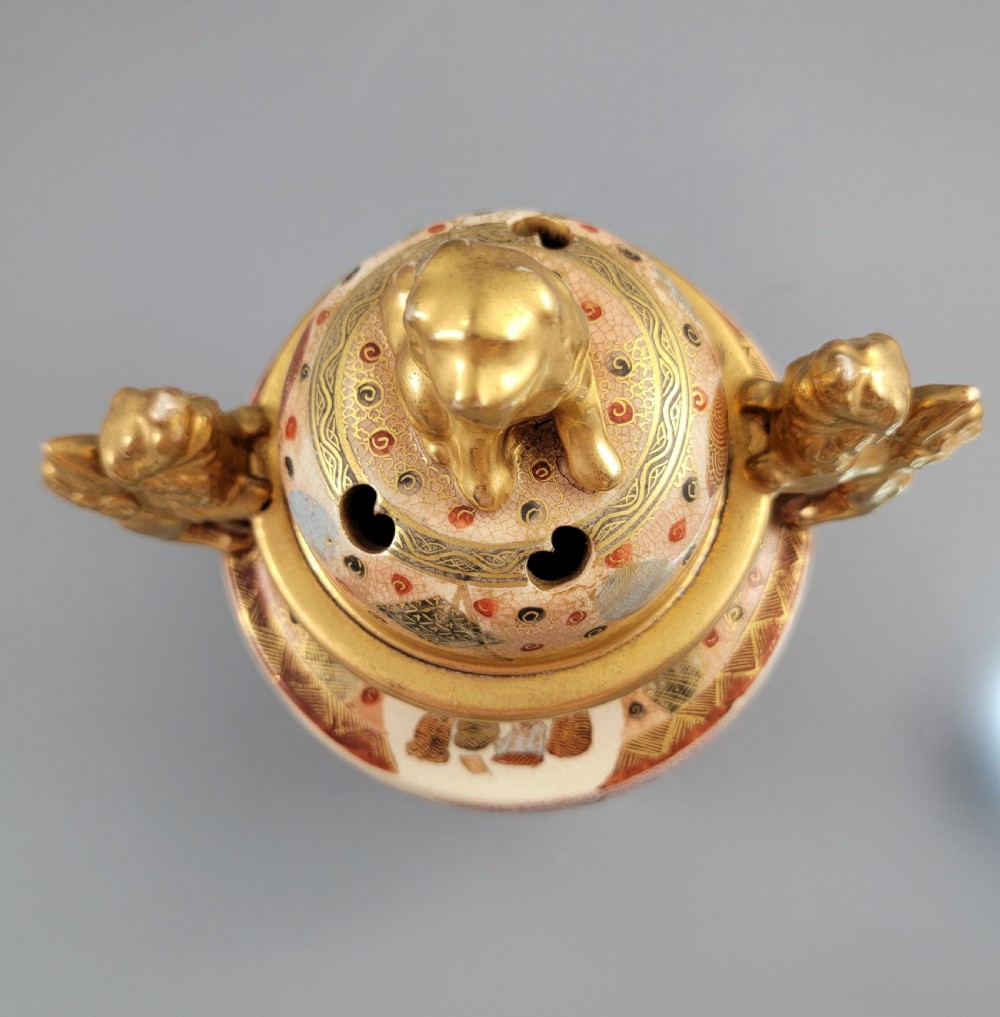 A Japanese Meiji period Satsuma earthenware incense burner featuring gilt shishi handles and finial with detailed hand-painted figures over a crackle glaze. View XI