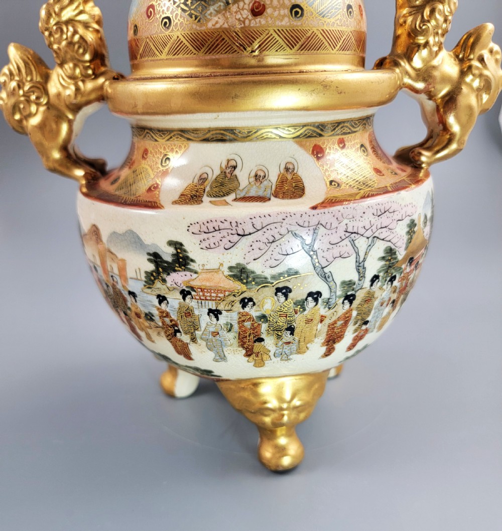 A Japanese Meiji period Satsuma earthenware incense burner featuring gilt shishi handles and finial with detailed hand-painted figures over a crackle glaze. View XVI