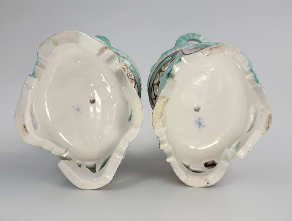 A pair of 19th-century German porcelain sweetmeat figures featuring sculpted children with birds beside reticulated baskets on ornate scrollwork bases. View VII