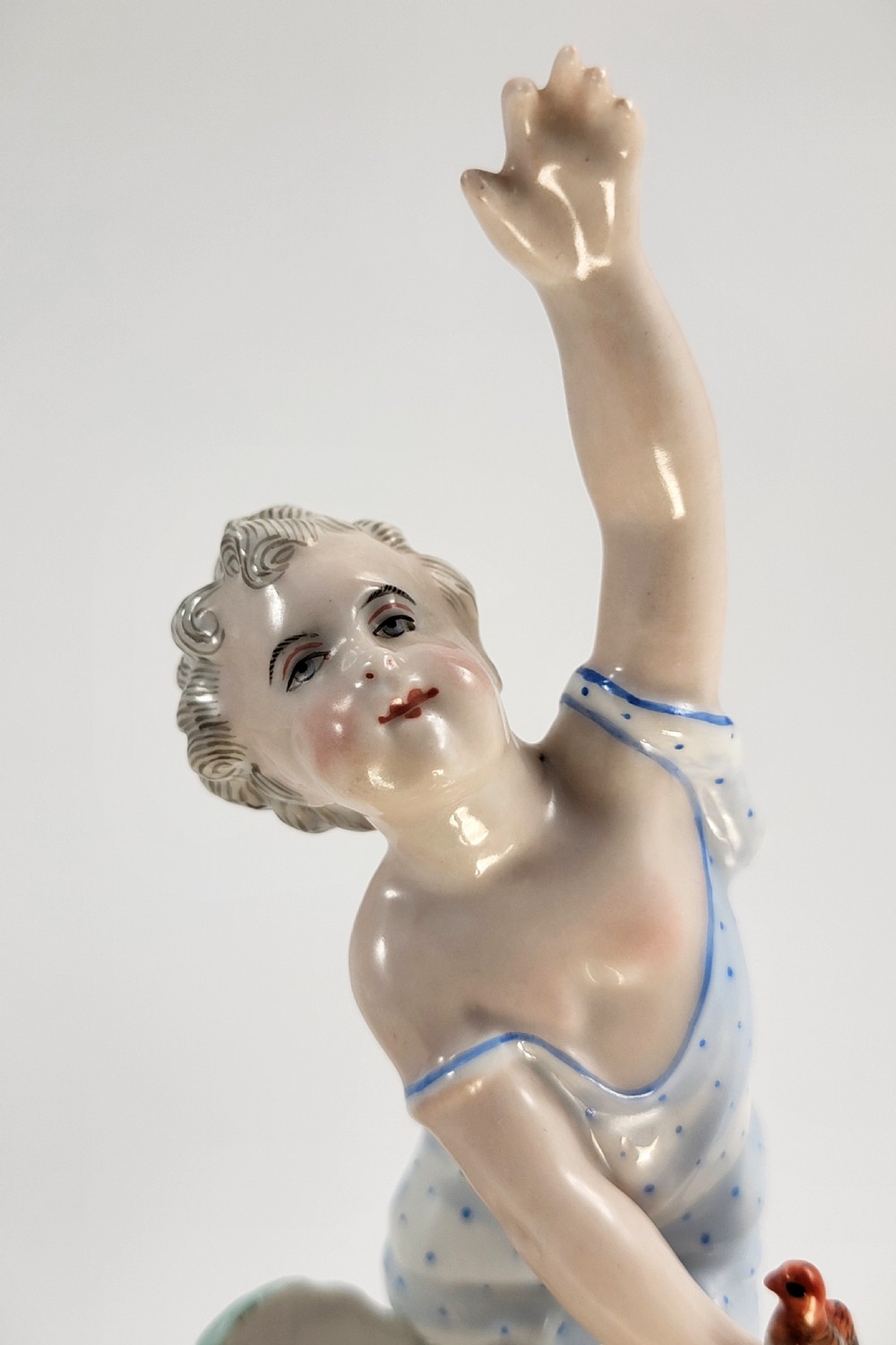 A pair of 19th-century German porcelain sweetmeat figures featuring sculpted children with birds beside reticulated baskets on ornate scrollwork bases. View XII
