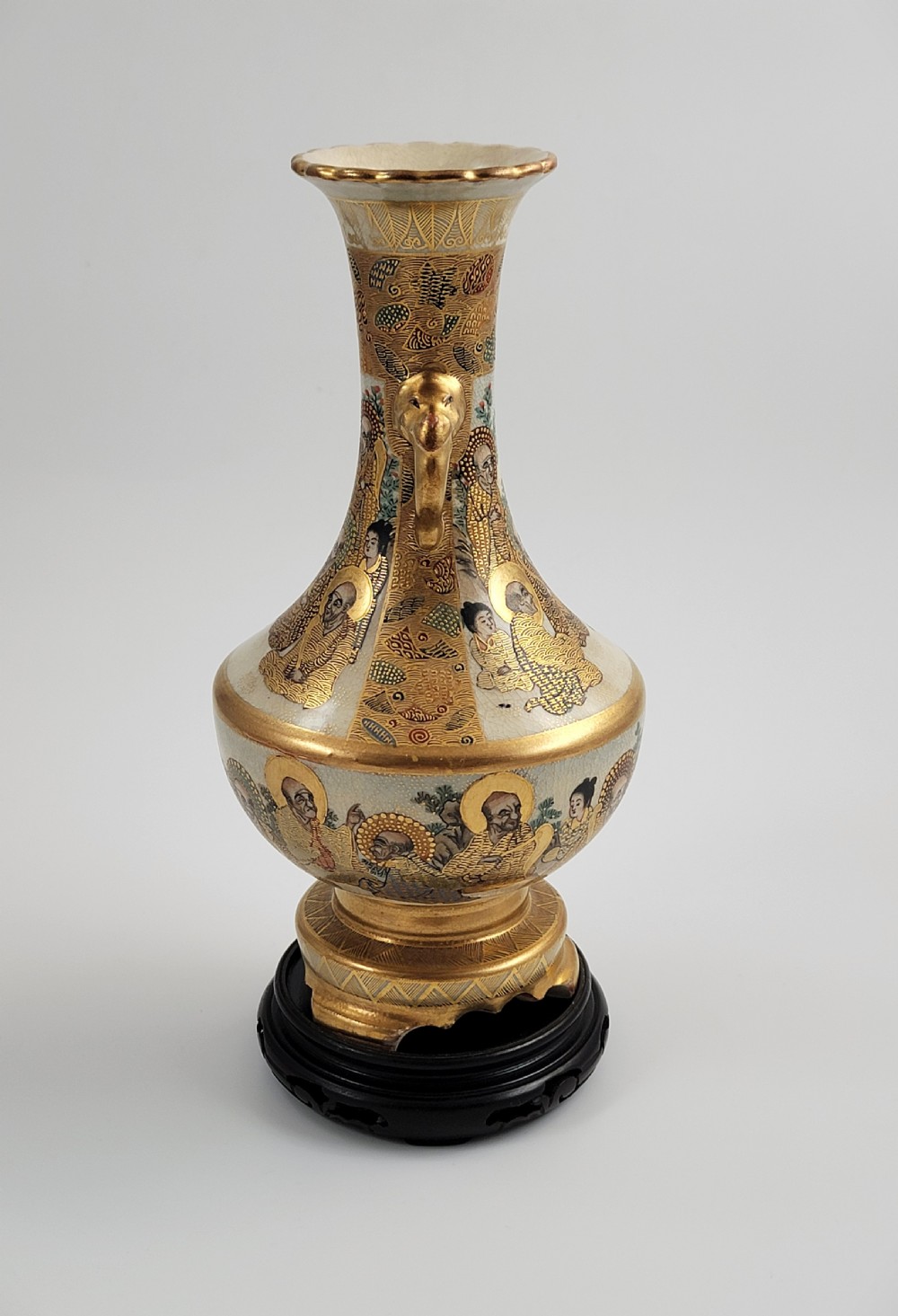An antique Japanese Satsuma earthenware vase featuring gilded elephant-head handles, hand-painted arhat figures, and intricate gold ornamentation. View VII