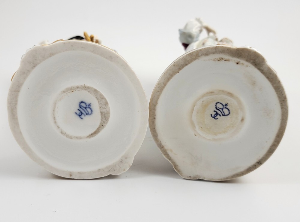 A pair of 18th-century hand-painted Ludwigsburg porcelain figures depicting a musketeer and a lady in detailed period attire standing on gilded Rococo scrollwork bases. View VI