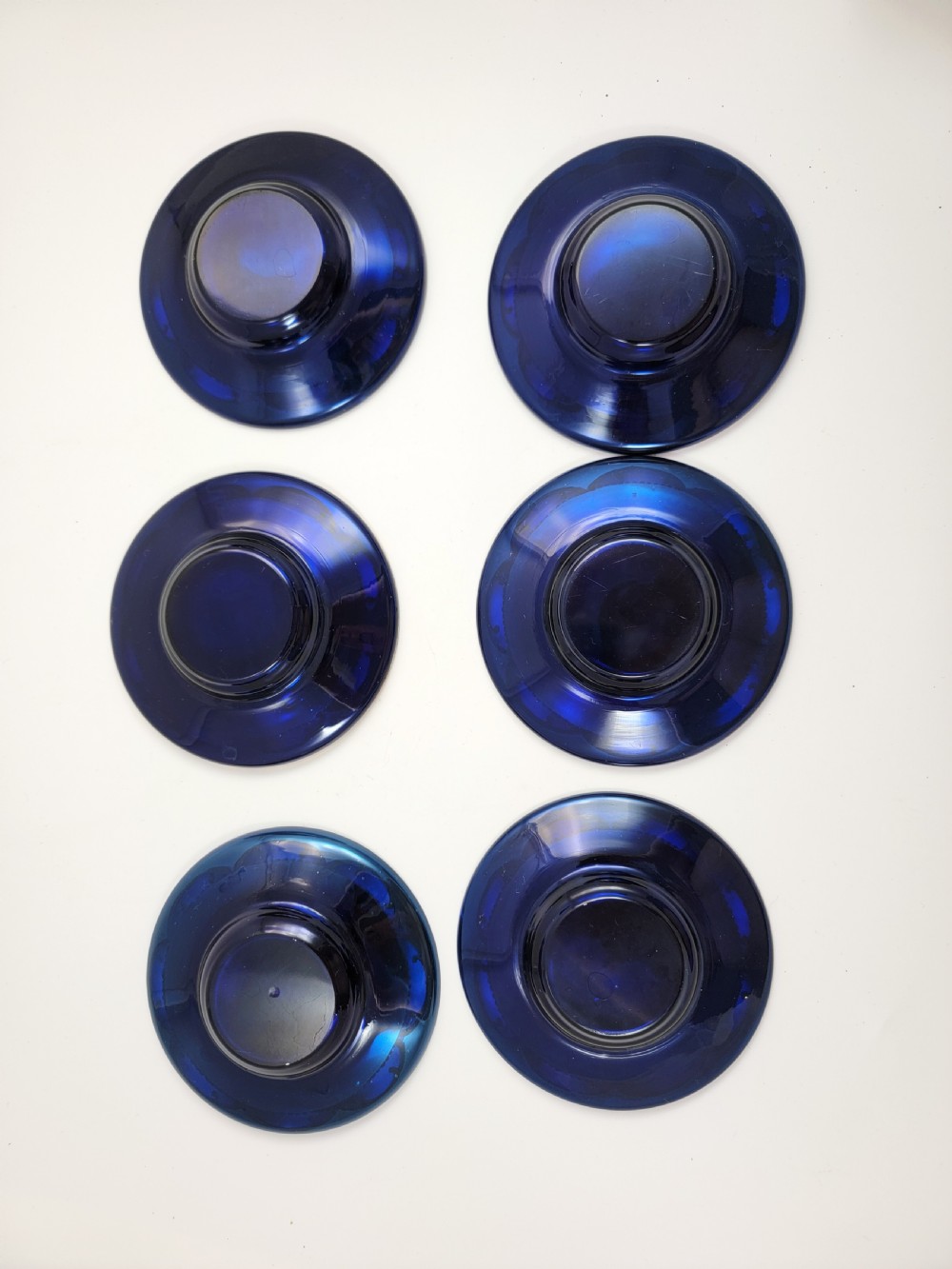 A set of six late nineteenth-century cobalt blue Bohemian glass tea cups and saucers featuring heavy gold gilding and raised enamel floral decoration. View V